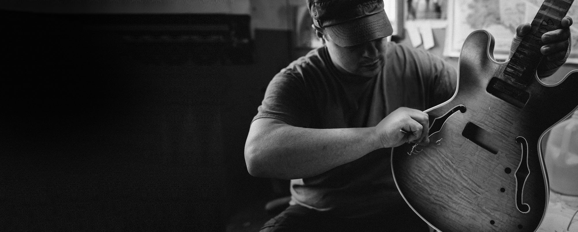 A luthier working on a guitar body